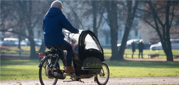 Elternteil und Kind auf einem Fahrrad.
