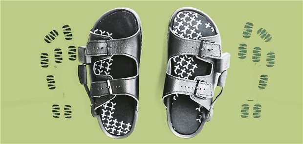 Was smarte Sohlen über die Folgen von Diabetes verraten In Sandalen liegen schwarze Einlegesohlen und daneben die Sensoren, die in den Sohlen verbaut sind