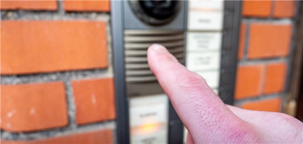 Ein Mann drückt auf eine Klingel.