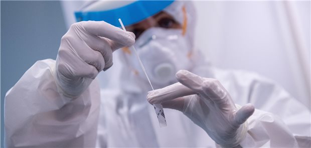 Wie SARS-CoV-2-Testung bei Patienten ohne Symptome abrechnen? Mitarbeiter an einem COVID-19-Testcenter am Flughafen in München.