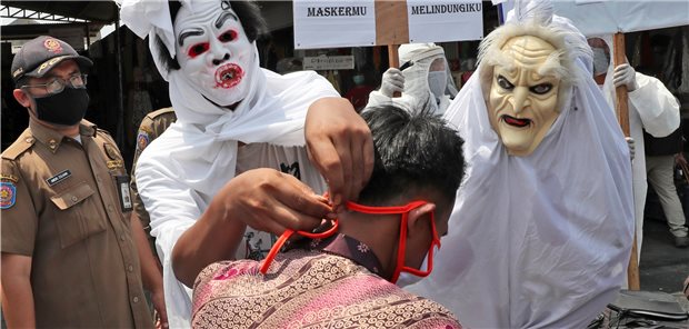 Geister gegen Masken-Muffel Mitarbeiter der indonesischen Gesundheitsbehörden, verkleidet als „Pocong“-Geister.