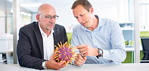 Modell eines Hepatitis-C-Virus: Alexander Würfel (rechts) im Gespräch mit "Ärzte Zeitung"-Chefredakteur Wolfgang van den Bergh.