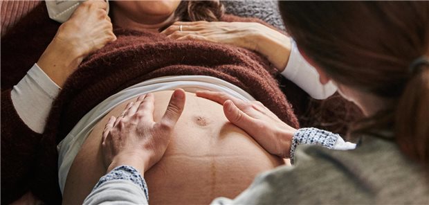 Hebamme tastet einen BAuch ab