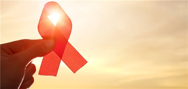 Aids-Symbol rote Schleife vor dem Himmel: Mundsoor kennen viele Mediziner als Hinweis auf eine HIV-Infektion, aber auch CMV-Infektionen?