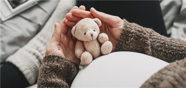 Schwangere Frau mit Teddy in der Hand