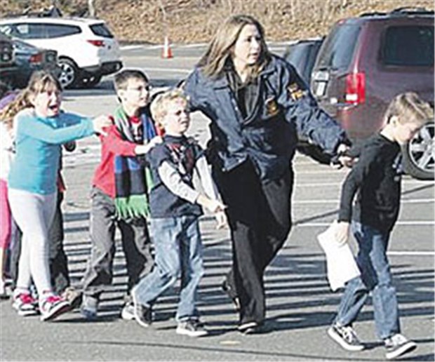 Amokläufer - gestört und von Medien zum Töten animiert? Nach dem Amoklauf in Newtown im US-Staat Connecticut bringt eine Polizistin Kinder aus der Schule.