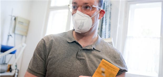 Spahn warnt vor gleichzeitiger Corona- und Grippewelle im Herbst Nach dem Piks: Bundesgesundheitsminister Jens Spahn (CDU) zeigt in einer Berliner Arztpraxis nach seiner Impfung gegen Grippe seinen gelben Impfpass.