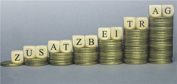 Vier Krankenkassen drehen an der Schraube des Zusatzbeitrags Geldstapel türmen sich