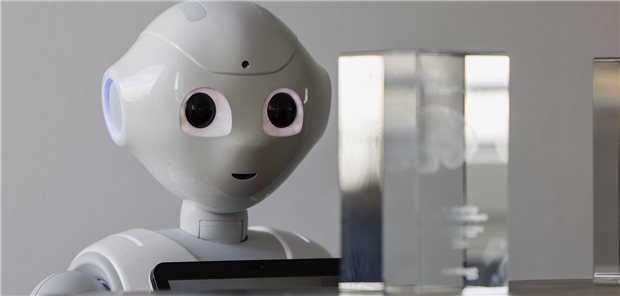 Ein Roboter, der künstlich intelligent sein soll, guckt eine Glasskulptur an.