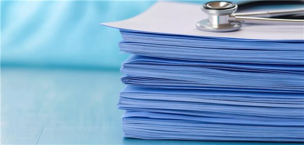 Aktenstapel mit Stethoskop oben drauf