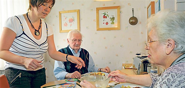 Verbände wehren sich gegen Alltagsbegleiter Neue Modelle in der Pflege: Eine Seniorenbegleiterin hilft einem Ehepaar in dessen Wohnung.