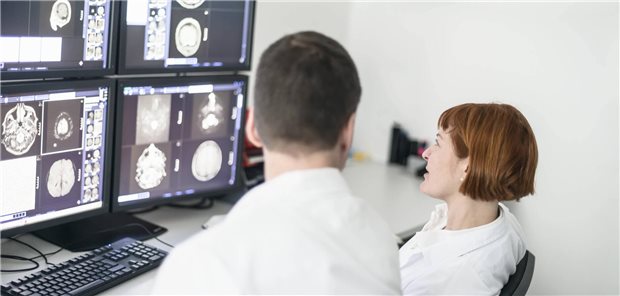 Two doctors discussing x-ray images on computer screen