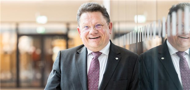 Niedersachsens Gesundheitsminister Andreas Philippi (SPD) lehnt an einer Glasfront und spiegelt sich darin.