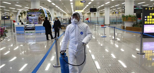 Nordkorea, Pjöngjang: Ein Mitarbeiter der Staatlichen Kommission für Qualitätsmanagement trägt am Flughafen der Hauptstadt eine Flasche mit Desinfektionsmittel. Es ist eine der Maßnahmen, um die Ausbreitung des Coronavirus zu verhindern.