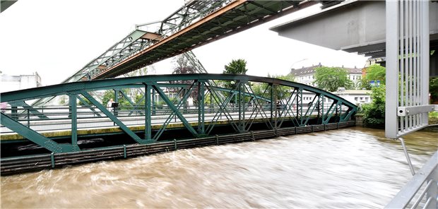 Ob Hochwasserschäden abgesichert sind, hängt vom Einzelfall ab 15.07.2021, Nordrhein-Westfalen, Wuppertal: Blick auf die überflutete Station der Schwebebahn in der Pestalozzistraße über der Wupper. Nach dem Unwetter mit sintflutartigen Regenfällen in NRW laufen die Aufräumarbeiten.