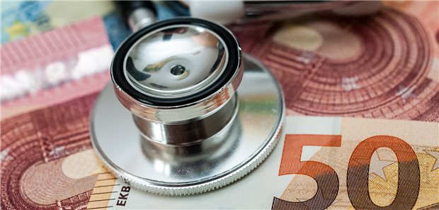 Ein Stethoskop liegt auf Geldscheinen.