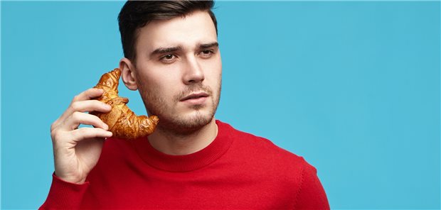 Nur ein Croissant am Ohr: Beim Essen sollte offenbar besser eine Smartphone-Pause eingelegt werden.