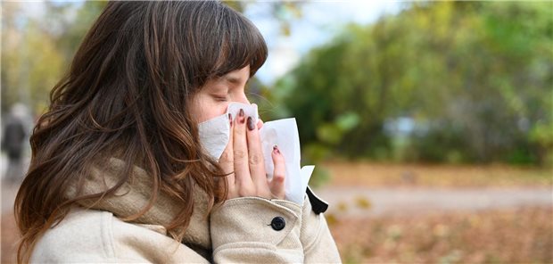 Weniger Praxisbesuche wegen Atemwegsinfektionen Eine Frau putzt sich die Nase.