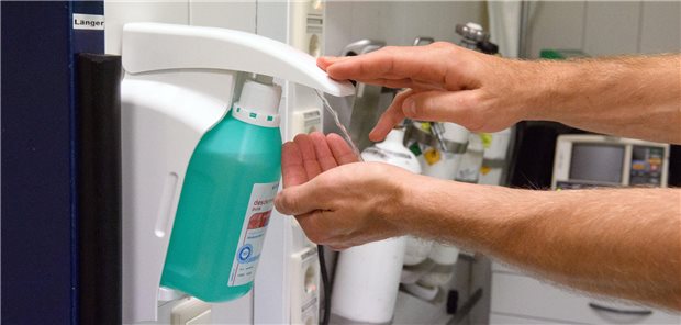 Ein Mann nutzt einen Desinfektionsspender
