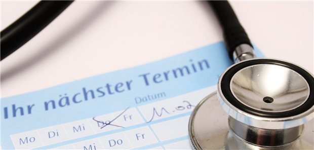 Stethoskop liegt auf einem Terminzettel für einen Arztbesuch.