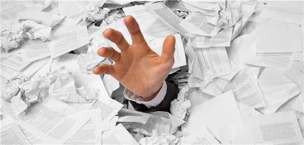 Umfrage der Ärzte Zeitung zur Entbürokratisierung: Ein Fünftel stimmt für weniger Kassenanfragen Hand greift aus Papieren