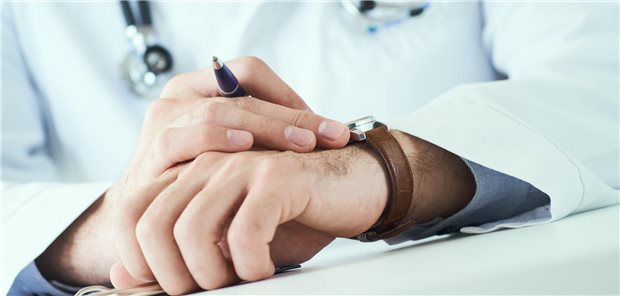 Ein Arzt schaut auf die Uhr.