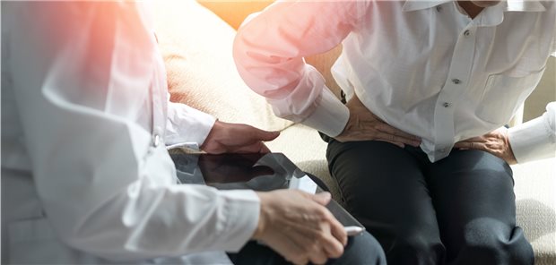 Patient krümmt sich mit Magen-Darm-Beschwerden beim Arzt – ein häufiges Bild in Hausarztpraxen: Bei welchen Patienten Dyspepsie ein Alarmzeichen für Krebs ist, haben Forscher in Thailand untersucht (Symbolfoto mit Fotomodellen).