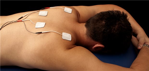 Patient mit Elektroden am Rücken: Bei der Anwendung der Transkutanen elektrischen Nervenstimulation (TENS) muss auf Wechselwirkungen mit der medikamentösen Schmerztherapie geachtet werden.