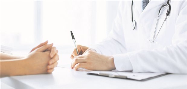 Patient sitzt vor Arzt