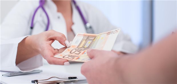 Patient zahlt Geld in der Arztpraxis