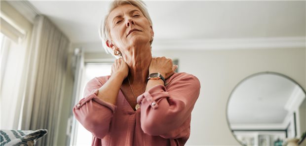 Eine Frau hält sich den schmerzenden Nacken fest