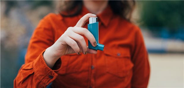 Frau mit Inhalator in der Hand.