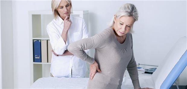 Patientin mit Rückenschmerzen bei ihrer Hausärztin. Empfehlungen für die Therapie finden Ärzte in einer neuen Praxisleitlinie (Symbolbild mit Fotomodellen).