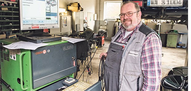 Inklusion als Motor Peter Beisenherz an seinem Arbeitsplatz bei der Abgasuntersuchung. In der KFZ-Werkstatt fühlt er sich wohl.