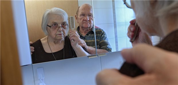 Mann hilft einer Frau beim Kämmen.
