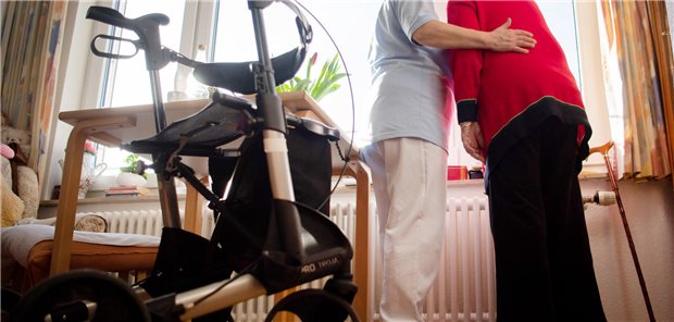 Pflegerin hilft Seniorin.