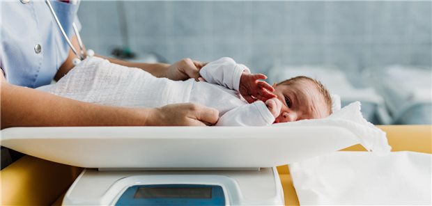 Fünf Kilo schweres Baby kommt auf natürlichem Wege zur Welt Pflegekraft misst Neugeborenes.
