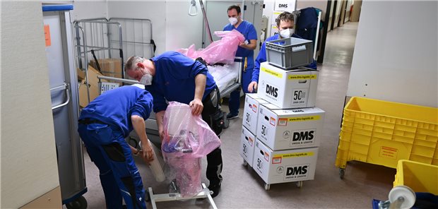 Wie eine Frankfurter Klinik im laufenden Betrieb ihr neues Passivhaus bezieht Pfleger Antonio Teixeira Ferreira (hinten) und Mitarbeiter einer Logistikfirma sind im Flur der Kardiologie des alten Klinikums Höchst mit Umzugsarbeiten beschäftigt. Insgesamt sind 7000 Umzugskisten zu bewältigen.