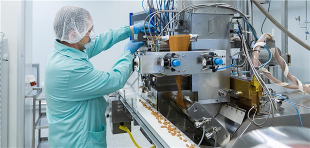 Pharmatechniker wacht in steriler Umgebung über den Produktionsprozess.