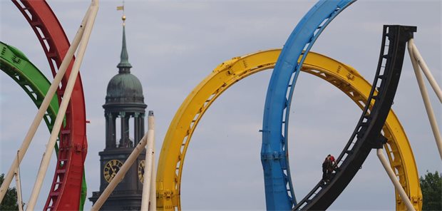 Das Foto zeigt eine Achterbahn vor dem Hintergrund der Hamburger Hauptkirche Sankt Michaelis.