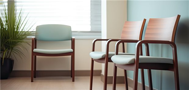 Ein Wartezimmer einer Arztpraxis, in dem drei leere Stühle stehen.