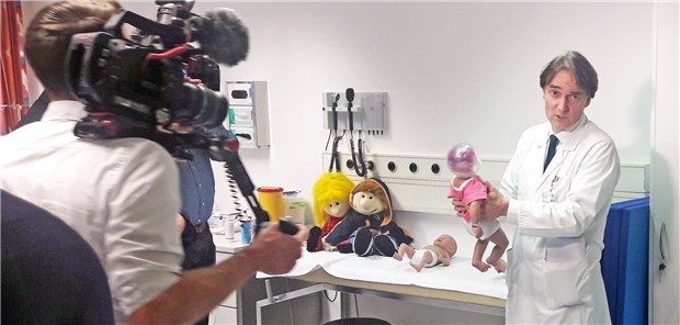 Kräftige Finanzspritze für Kinderschutzambulanz Professor Matthias Kieslich, verantwortlicher Arzt der Kinderschutzambulanz an der Uniklinik Frankfurt, demonstriert typische Misshandlungsverletzungen von Kindern anhand einer Puppe.