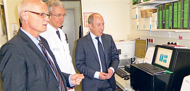 Barmer bezahlt jetzt personalisierte Therapie Professor Reinhard Büttner, Professor Jürgen Wolf und Dr. Mani Rafii neben einem Sequenzer im Institut für Pathologie der Uniklinik Köln (v.l.).