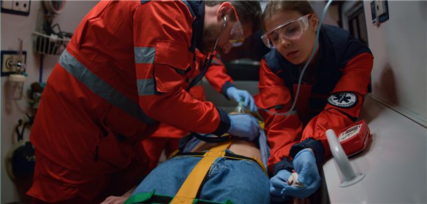 Zwei Rettungssanitäter leisten medizinische Hilfe für einen Patienten im Krankenwagen.