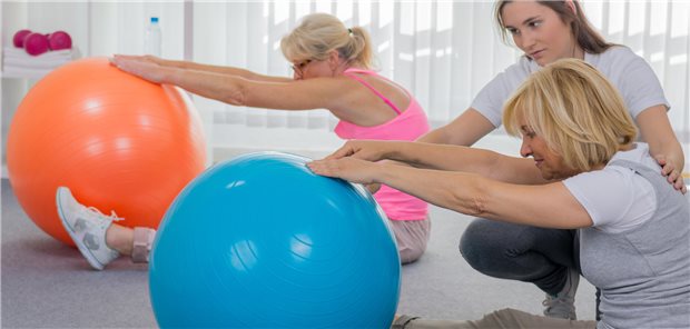 Senioren machen Übungen auf dem Gymnastikball.