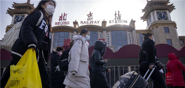 Umstrittene SARS-CoV-2-Todeszahlen aus China Reisende mit Mund-Nasen-Schutz gehen mit Koffern an dem Zentralbahnhof in Peking vorbei. Lockdowns gibt es vorerst keine mehr in China, auch die nächste Reisewelle wird trotz vieler COVID-19-Erkrankungen nicht von der chinesischen Politik unterbunden werden.