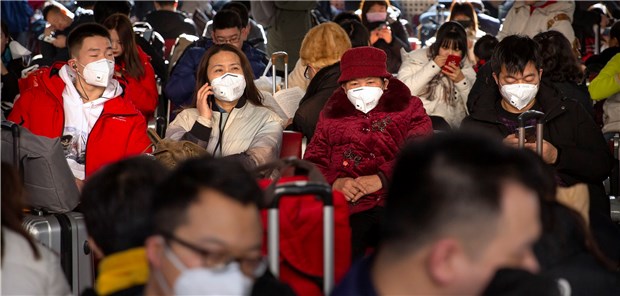 Reisende tragen als Schutzmaßnahme gegen die Verbreitung des Corona-Virus Mundschutz, während sie in einem Warteraum am Pekinger Westbahnhof sitzen.