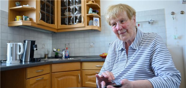 Die blinde Patientin Renate S. bedient ein Smartphone für Blinde in ihrer Küche.