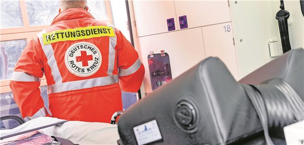 Sanitaeter mit Uniform und Aufschrift Rettungsdienst in einem Intensivtransportwagen des Deutschen Roten Kreuz.