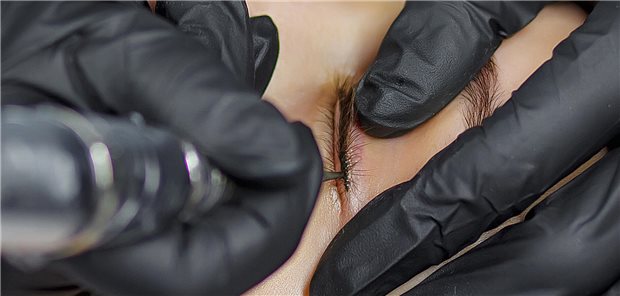 Eine Frau lässt sich in einem Kosmetikstudio permanent Eyeliner auftragen.